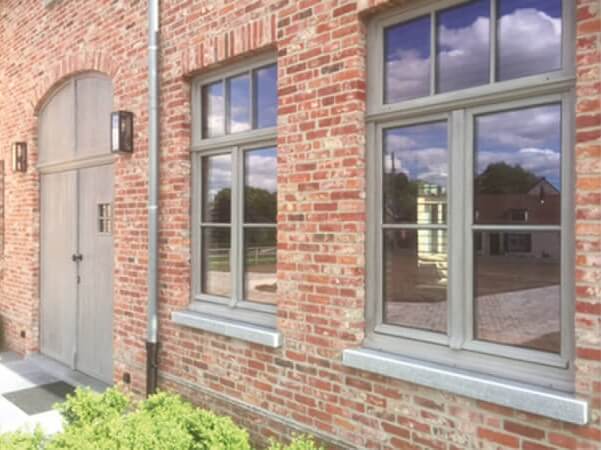 Side shot of a brick building with a rustic white wood and window sills finished with an exterior wood oil finish.