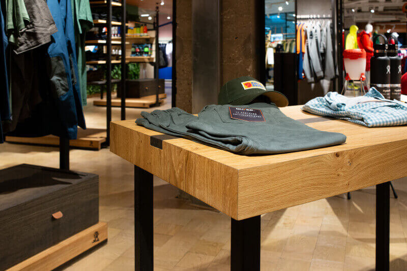 A wooden merchandising table finished with Rubio Monocoat oil finish.