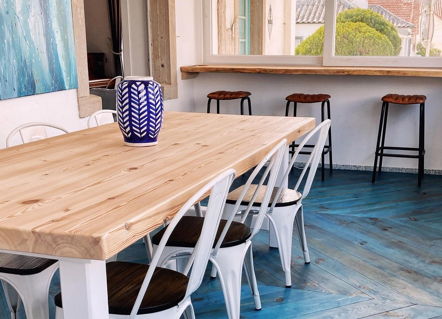 A dining table with six chairs sit atop a blue chevron floor.