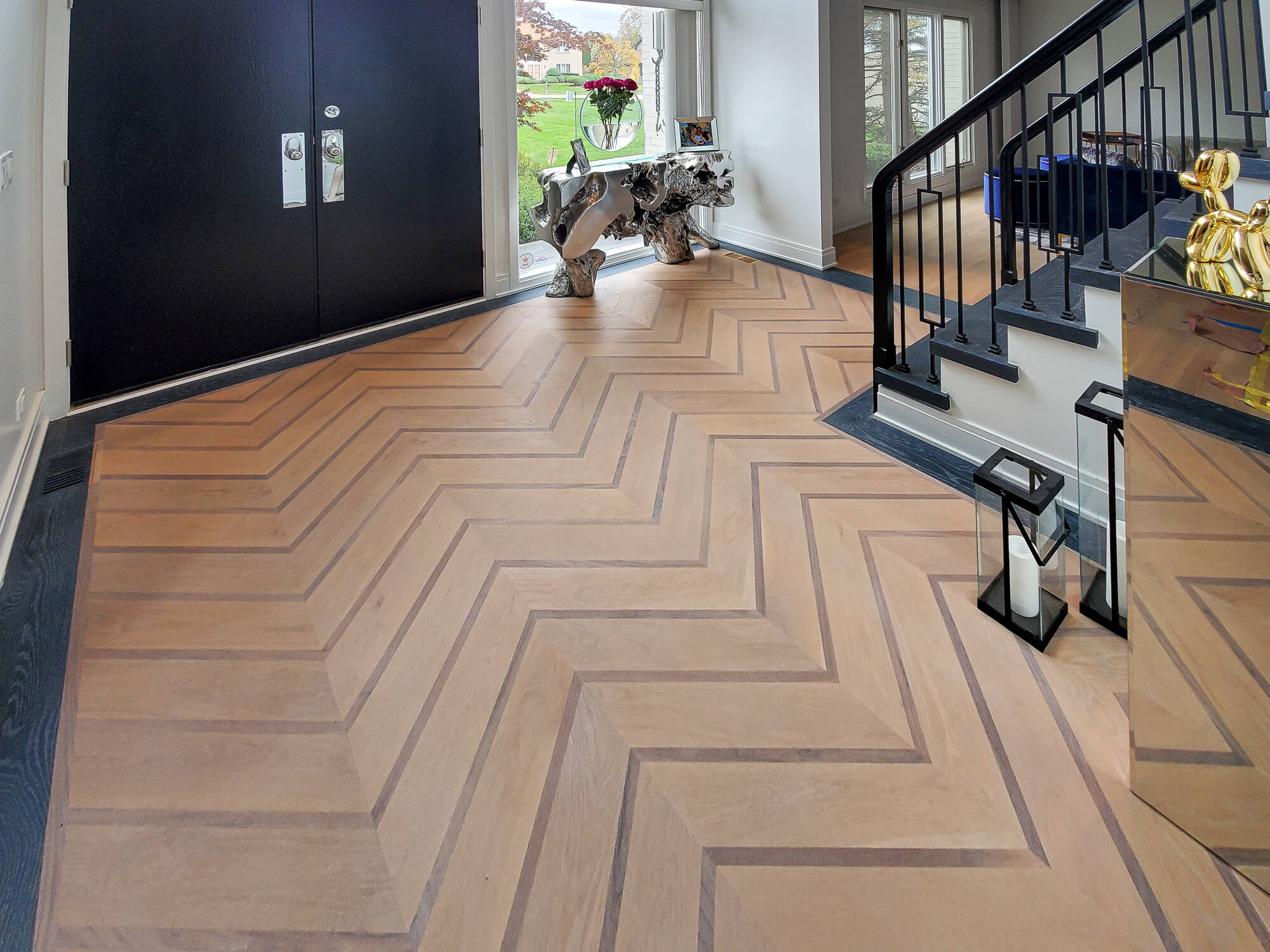 Custom chevron white oak floor with walnut accent strips and a cerused border.