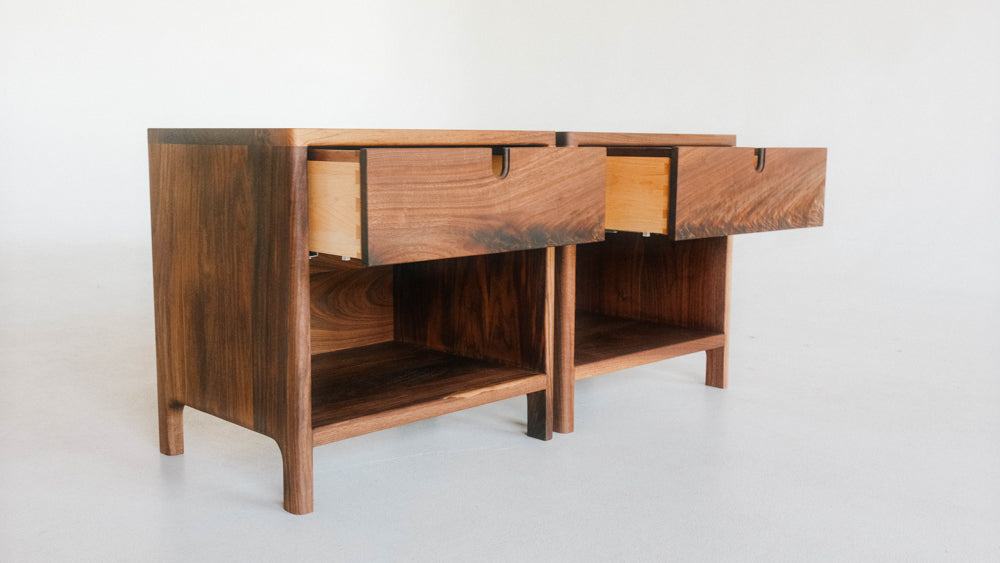 Two modern, Danish-inspired walnut side tables finished with a hardwax oil wood finish.