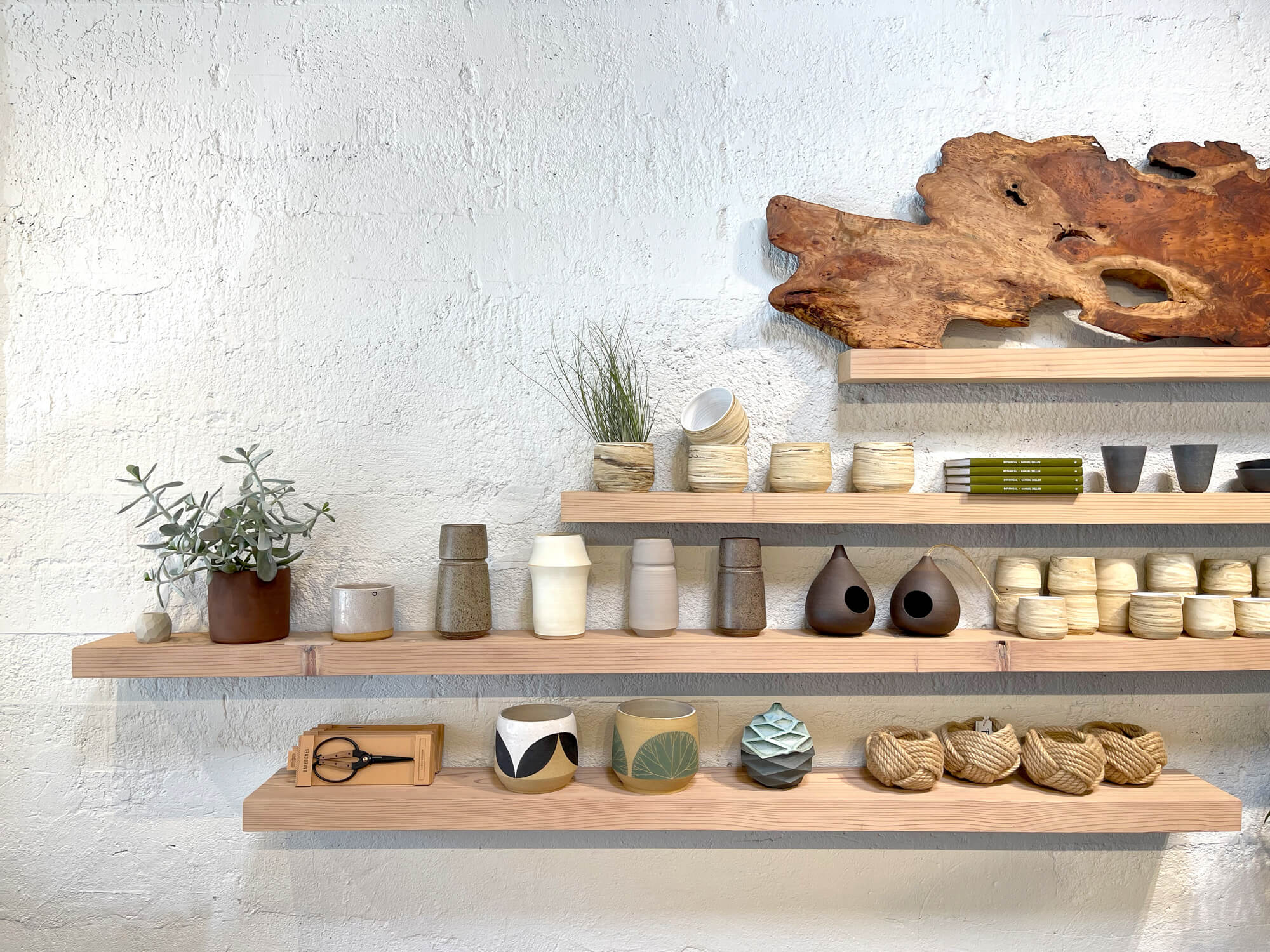 Redwood shelves displaying pottery and other small artifacts.