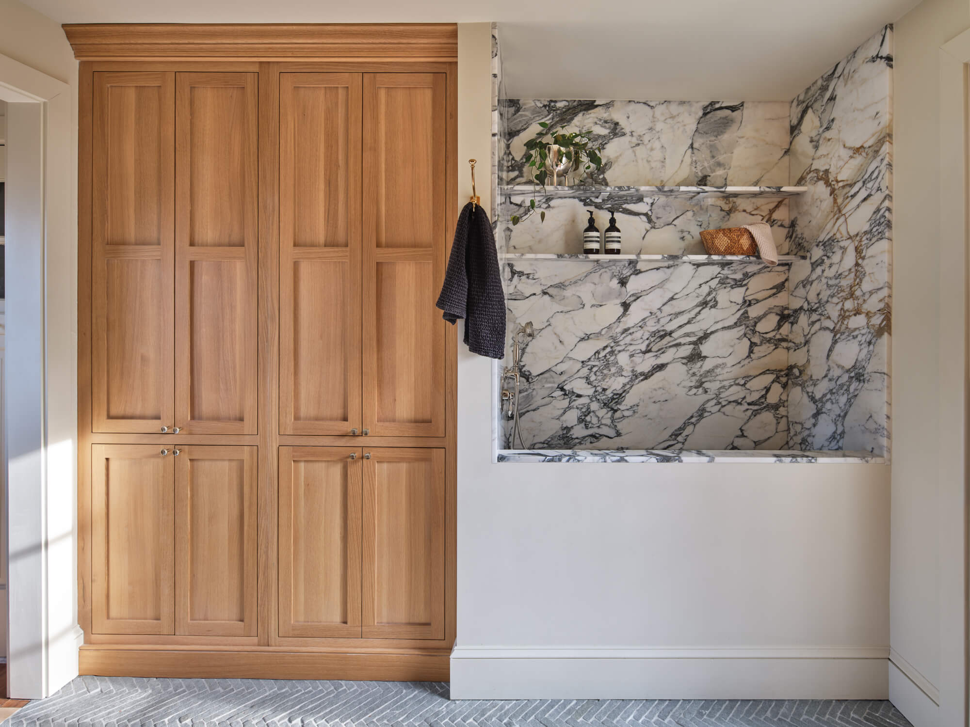 White oak built-in cabinetry finished with a hardwax oil wood finish with a marble dog wash station.