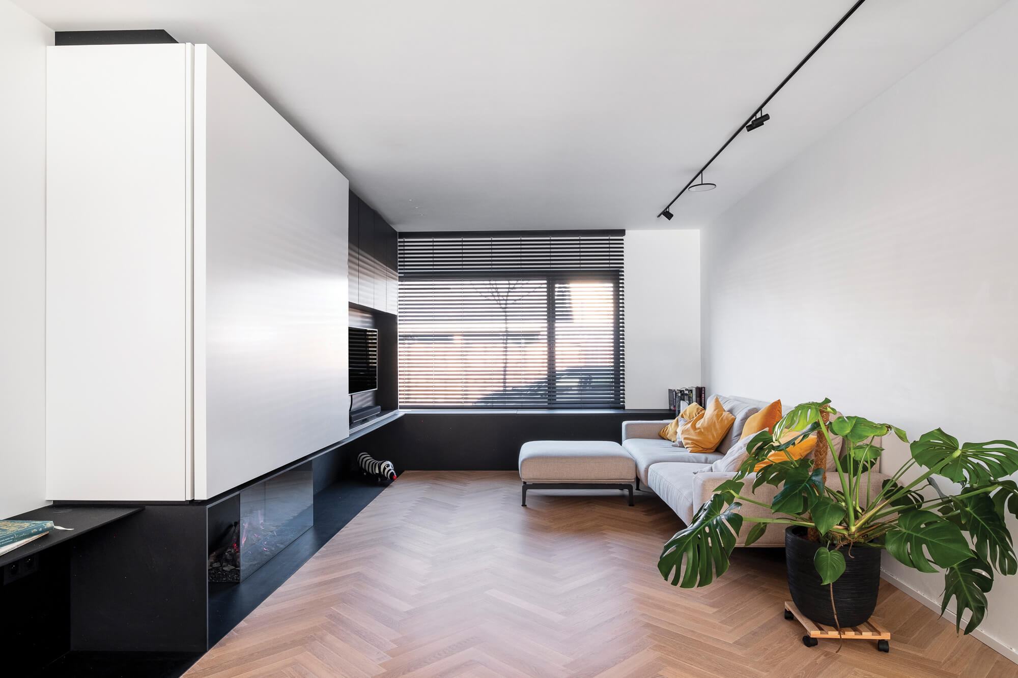 White oak herringbone flooring in the living room of a modern minimalist home.