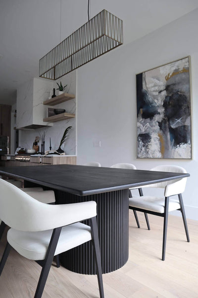 A black fluted white oak dining table with white chairs made from fabric and wood.