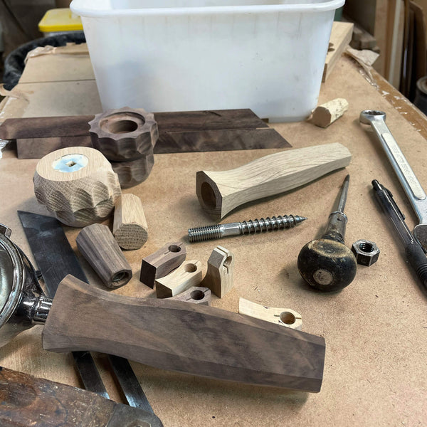 Various walnut espresso machine parts that are unfinished.