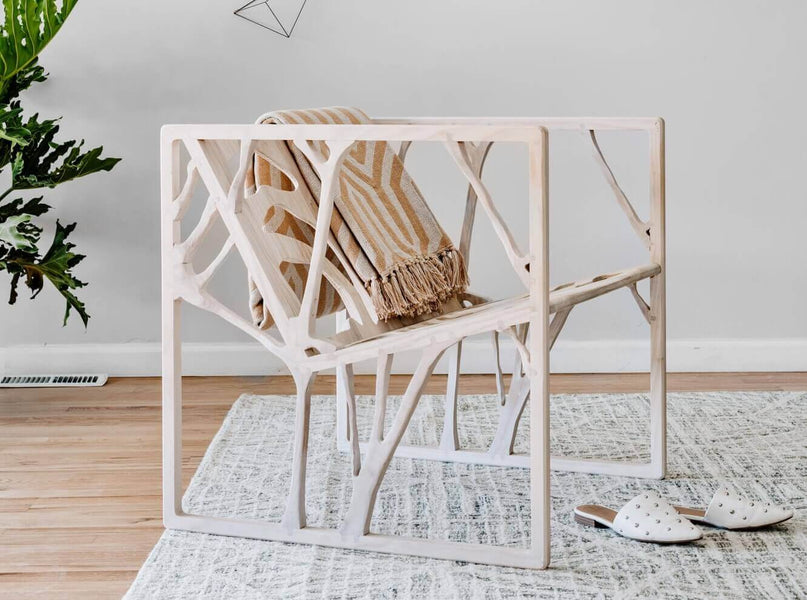 An ash dispersion chair finished with a hardwax oil has a blanket on the back of it and a pair of shoes in front of it