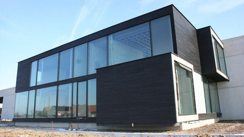The entire side of a modern home finished with glass paneling and wood siding.