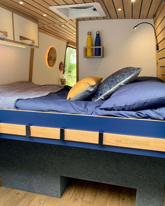 Conversion van bed with plenty of storage both underneath and overhead.