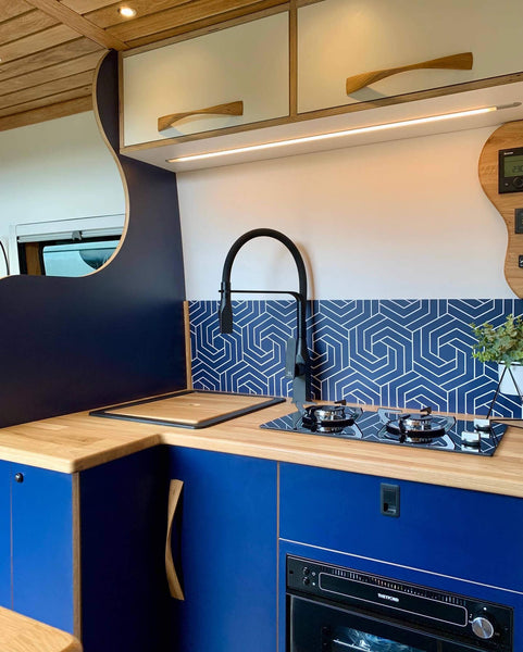 Small blue kitchen in a conversion van camper.