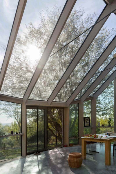 Glass sun room with wood beams inside.
