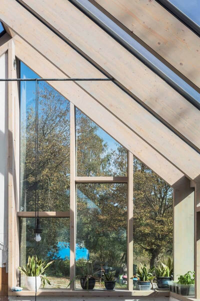 Wood beams holding up glass panels in a sun room.