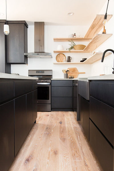 White oak flooring in a modern kitchen that had black cabinets and white oak floating shelves.