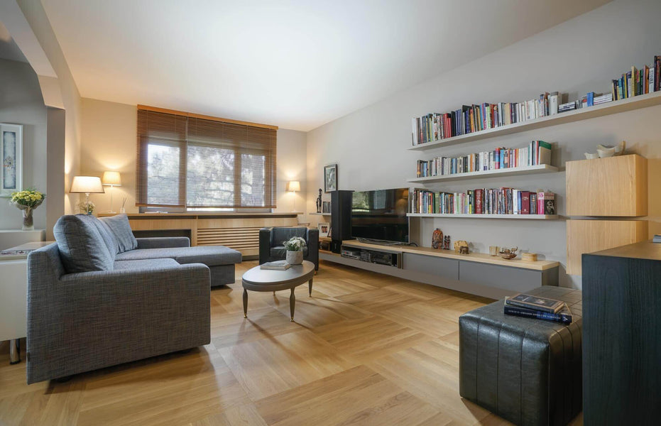 Parquet wood flooring in a living room with floating shelves.