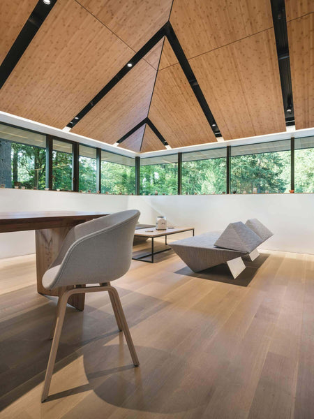 Room lots of windows, wide plank wood flooring and a wood ceiling.