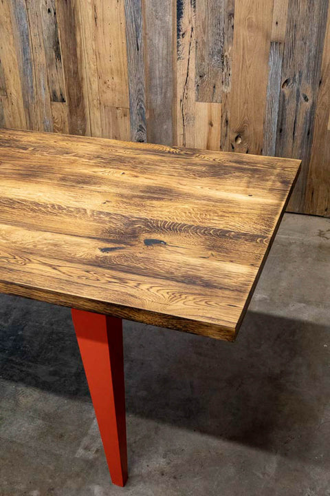 Charred white oak dining table with orange legs.