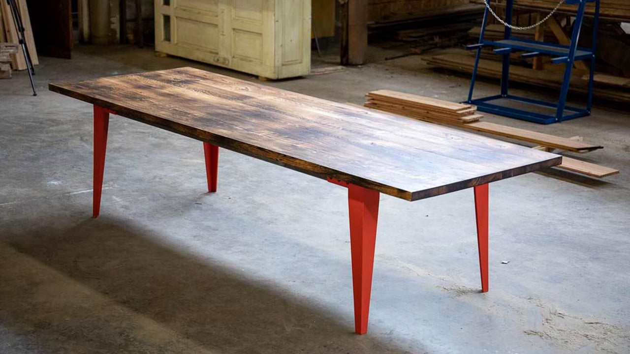 A dining table with a charred look finished with Rubio Monocoat Oil Plus 2C and blue metal legs.