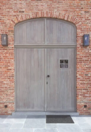 A large wooden door with rustic white wood finish on it.