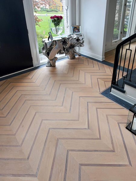 Residential foyer with custom chevron hardwood flooring pattern, made from white oak and walnut, finished with a natural hardwax oil wood finish.