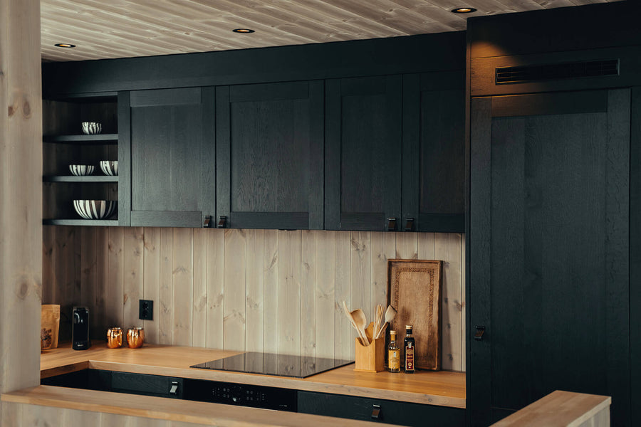 Contrasting kitchen with light wood countertops and black kitchen cabinets finished with Rubio Monocoat products.