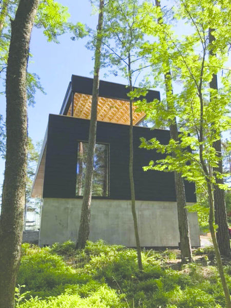A modern home surrounded by trees.