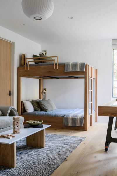 A modern white oak bunk bed in a bedroom.