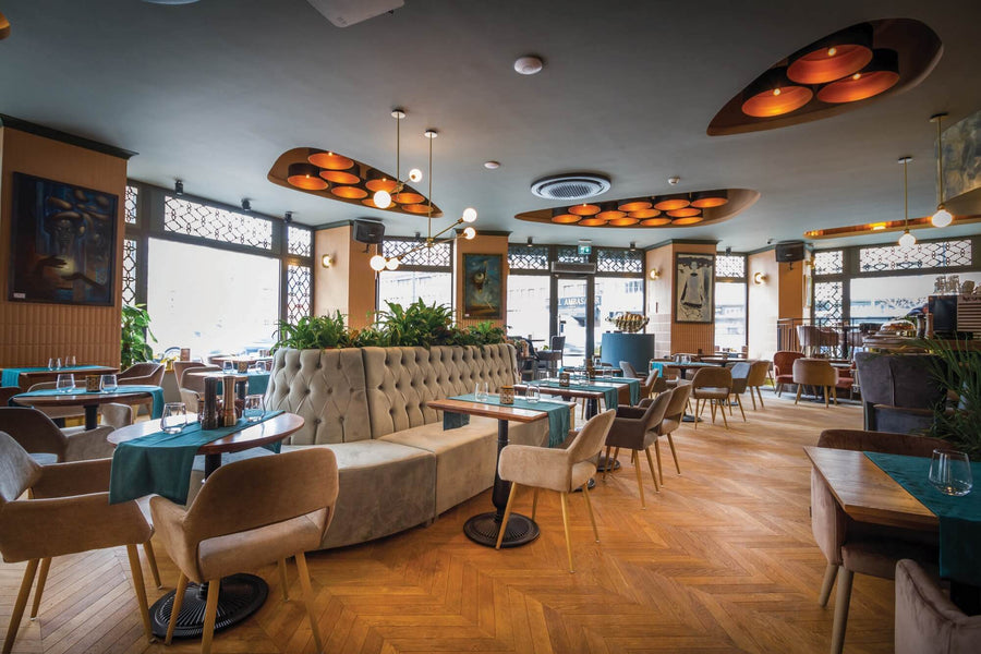 Open restaurant design with chevron wood floors.