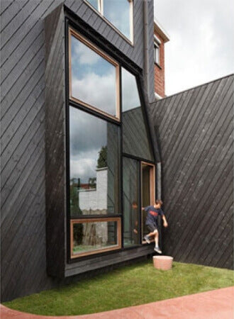 The back side of a modern design home with wood siding.