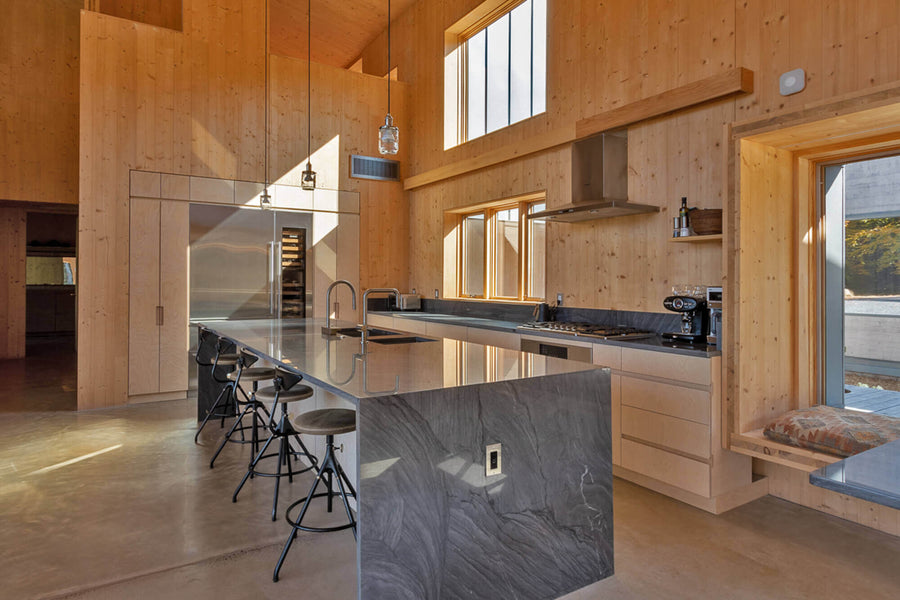 Lodge style kitchen with grey waterfall kitchen island and tall ceilings.