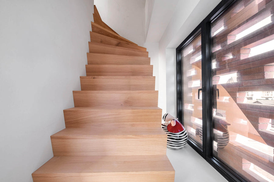 Curving staircase made from white oak leading to the second story.