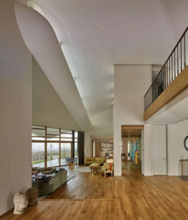 Hardwood flooring in a living area and high curved ceiling accents.