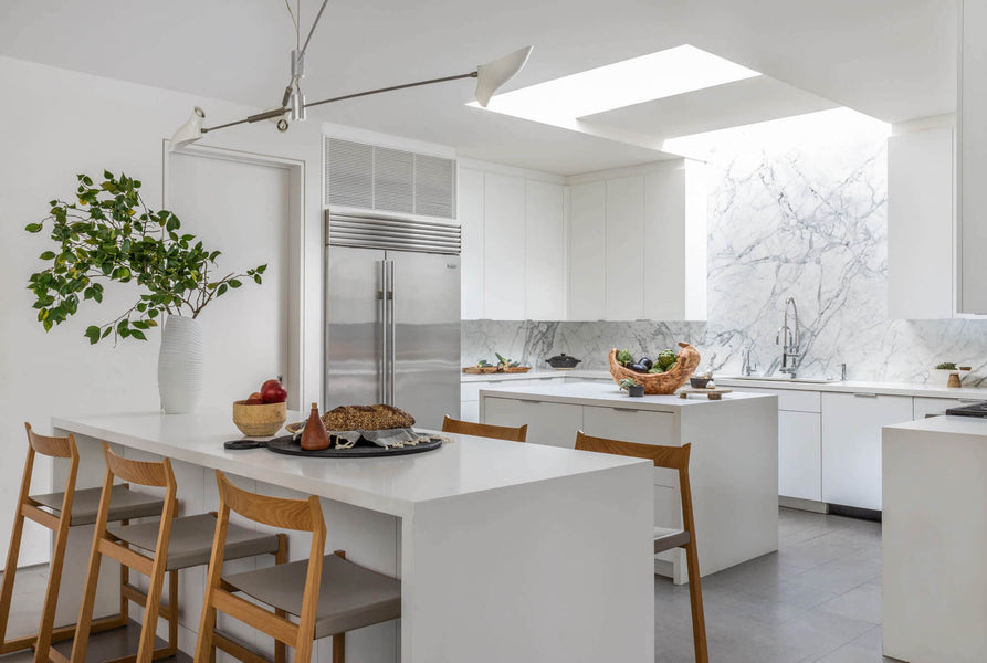 Modern white kitchen with two parallel islands and a skylight.