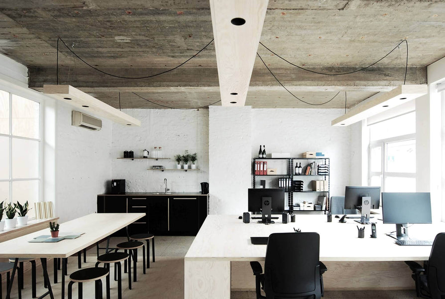 Architectural offices with white bricks, grey ceiling, and light plywood accents throughout.