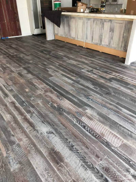 A living room with skip and miss oak hardwood flooring and a cerused finish color.
