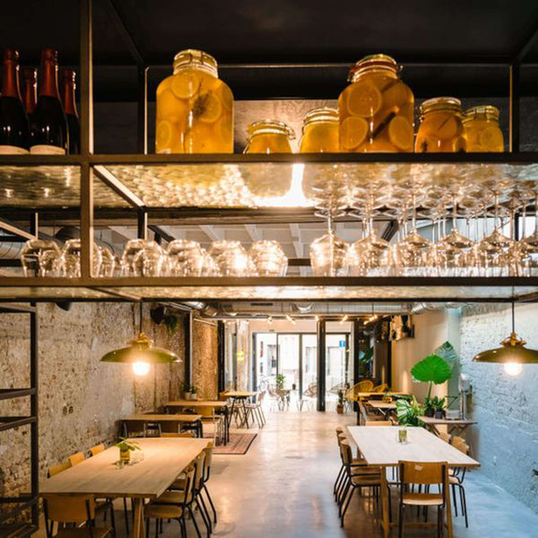 A view from the top of the bar, glasses and other kitchen items sit in a suspended rack overlooking a seating area.