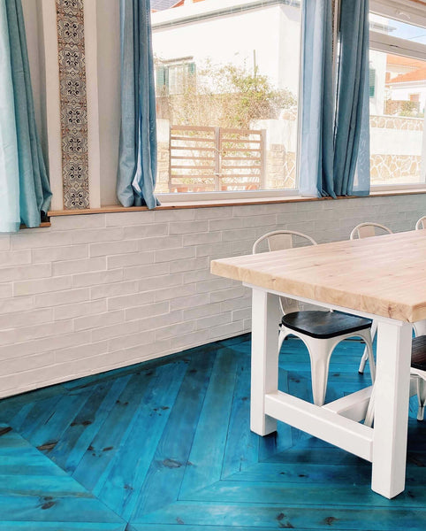 Blue chevron floors draw you into this dining space with a window looking out towards the sea.