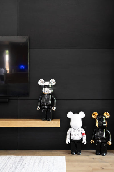 Three Mickey Mouse Star Wars figurines are lined up against a black stained wall.