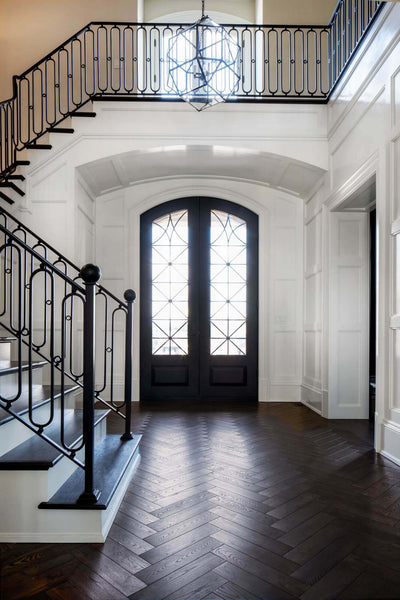 Herringbone wood flooring that won NWFA Wood Floor of the Year in an entry with stairs on the left.