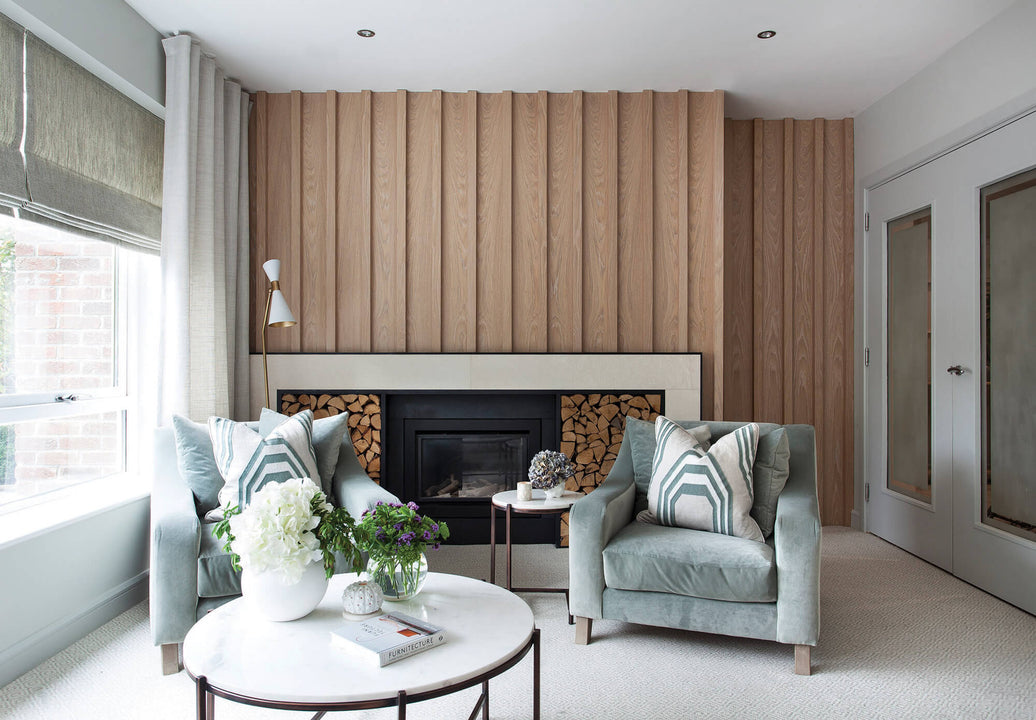 Vertical white oak fluted paneling finished in Rubio Monocoat Oil Plus 2C Natural wraps a fireplace wall and continues onto an adjacent closet surround.