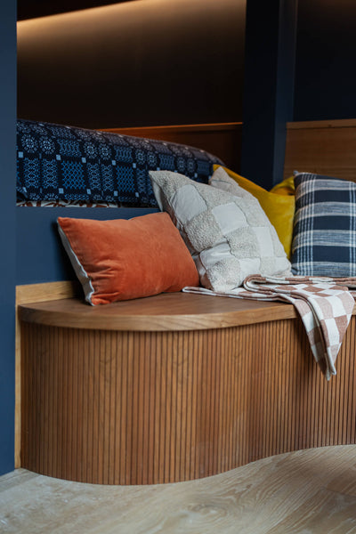 Cherry bench off a built-in bunk bed.