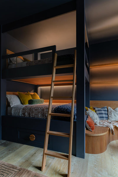 A set of bunk beds with a ladder made from cherry wood.