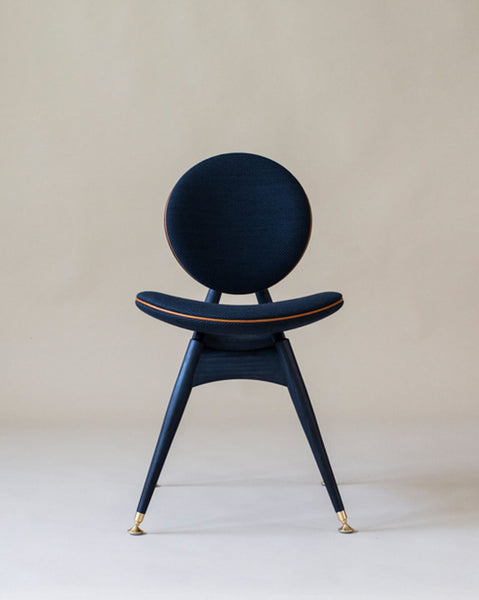 A modern dining chair featuring a circle back and seat made from ash wood.