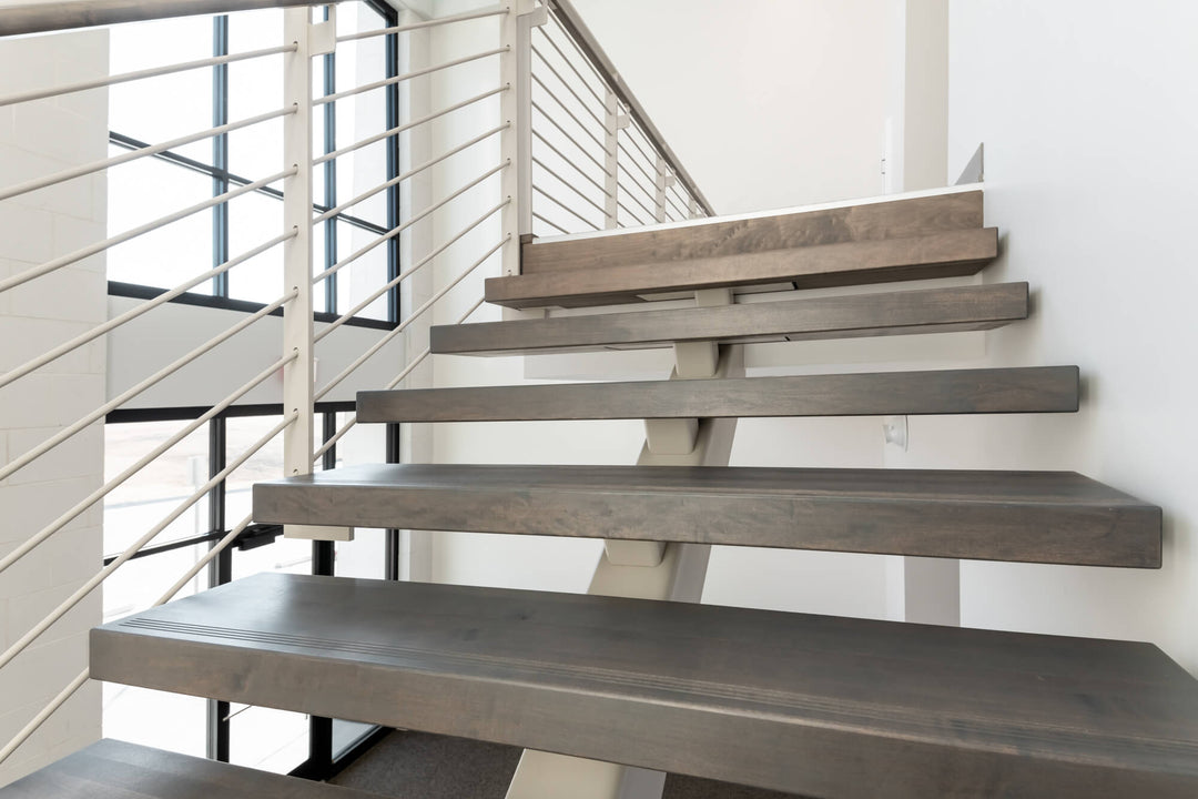 Custom grey-stained maple stair treads on a mono-stringer.