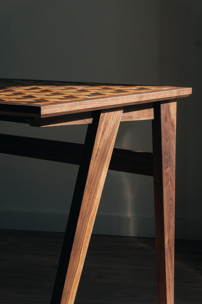 Side view of a modern desk made from walnut wood.