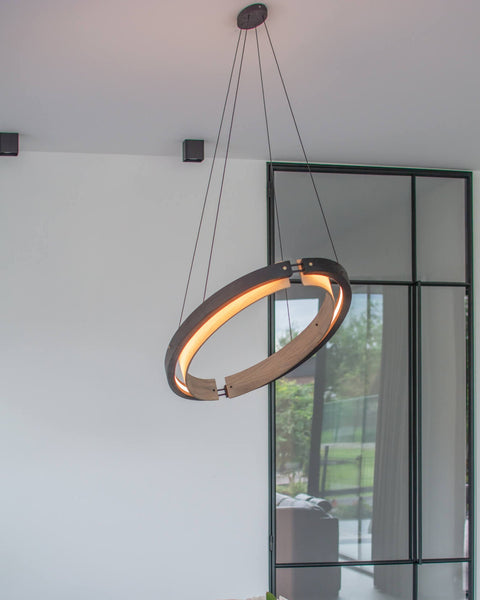 A double halo hanging light fixture made from oak wood and finished with Rubio Monocoat products.