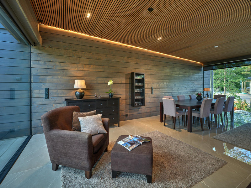 A living and dining area fit with spruce cladding finished with Rubio Monocoat Precolor Easy Cashmere Brown and Oil Plus 2C Oyster.
