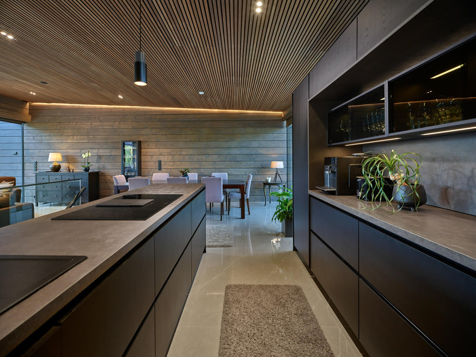 A kitchen in a modern log-style home with spruce cladding treated with Precolor Easy and Oil Plus 2C.