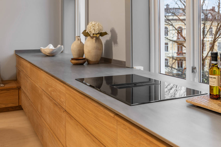 A kitchen with windows, electric cooktop and warm European oak cabinetry finished with Oil Plus 2C "Mist 5%".
