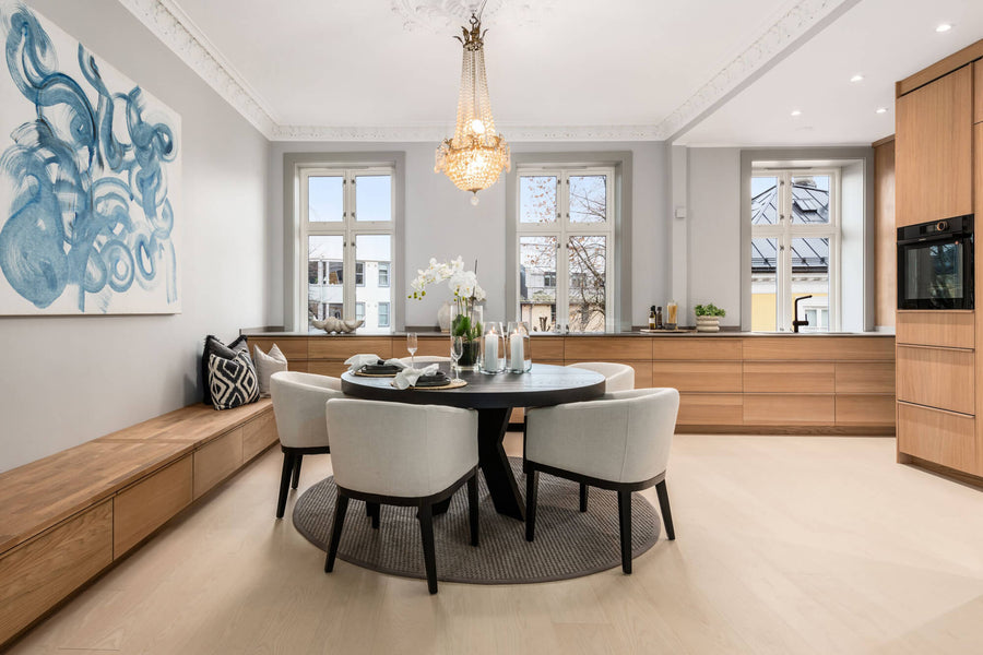 A contemporary kitchen with modern oak cabinetry finished with Rubio Monocoat Oil Plus 2C hardwax oil. A small dining area with a bench across one wall is also featured.
