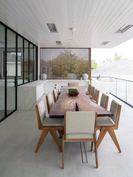 An enormous dining table made from exotic wood finished using a clear hardwax oil wood finish.